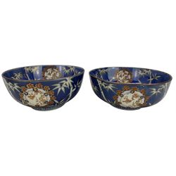 Set of four Japanese graduating porcelain bowls, each centrally painted with a coiled dragon in reserves, bamboo and foliate roundels against a blue ground, largest measuring D24.5cm (4)