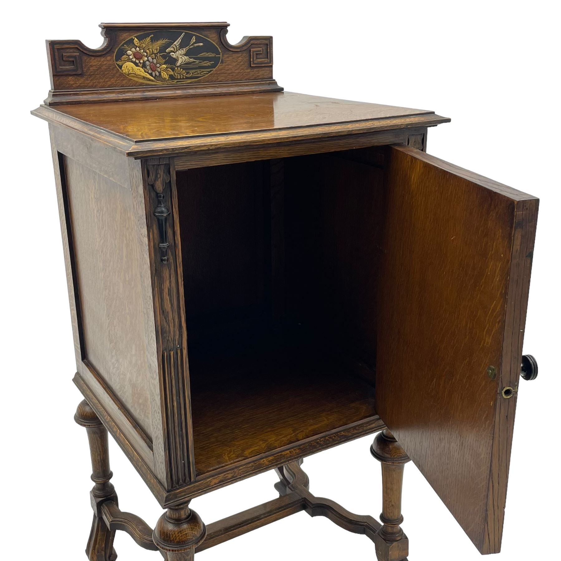 Early 20th century circa. 1920s oak bedside cupboard, raised back decorated with chinoiserie lacquer work depicting bird and flowers, moulded top over single door decorated with figure carrying bird cages, on turned supports united by shaped moulded stretchers, scroll carved feet