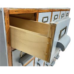 Mid-20th century multi-drawer chest or filing cabinet, fitted with twenty-five small drawers with wooden handles and metal label holders, in light blue paint finish 