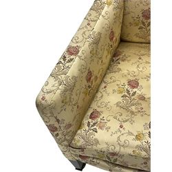 Edwardian hardwood-framed armchair, upholstered in floral pattern fabric, on square tapering front supports, brass and ceramic castors 