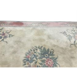 Chinese ivory ground washed woollen carpet, the field decorated with five large floral motifs with extending leafage, the wide rose guard band decorated with further floral patterns