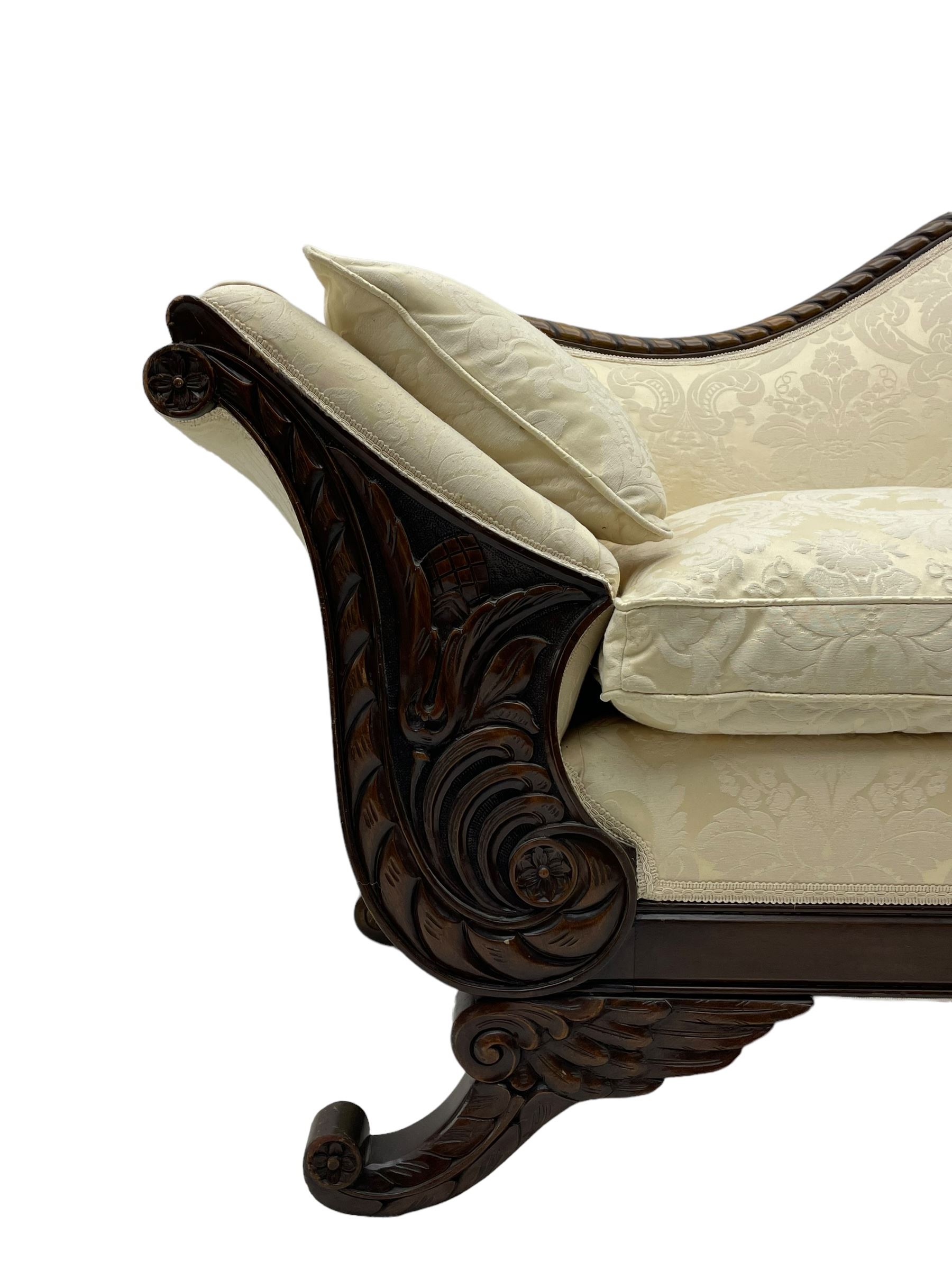 Victorian design walnut framed settee, shaped camelback with gadroon carved edge and central feather motif, upholstered in cream damask fabric with scrolling floral pattern, S-scroll arm facias carved with flower head and curled leaves, feather carved C-scroll splayed feet 