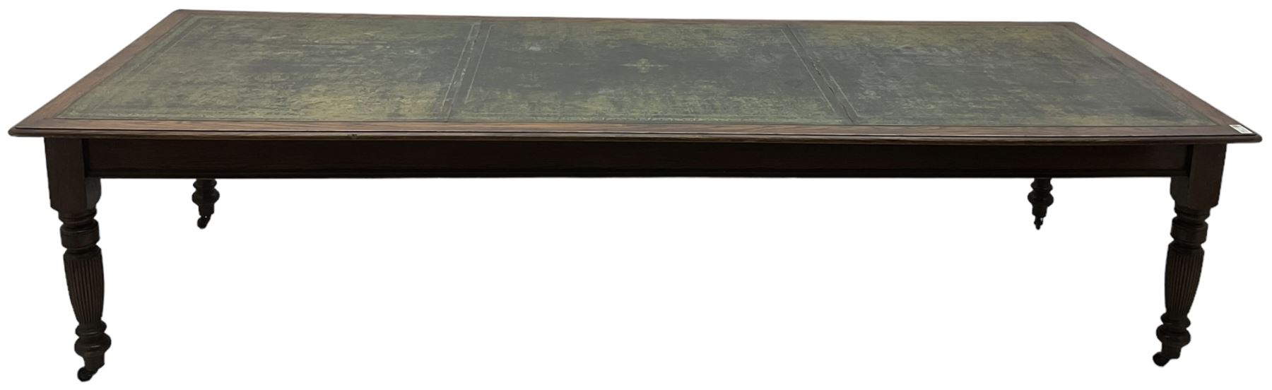 Large 10' 7'' late Victorian oak boardroom table, moulded rectangular top with inset green leather surface, on turned and reed moulded supports with brass and ceramic castors 