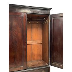 19th century Irish mahogany press wardrobe, projecting dentil cornice over two figured panelled doors, enclosing three sliding trays and hanging rail with coat hooks, fitted with two drawers to base over a shaped apron, raised on acanthus carved cabriole supports with paw feet, retailed by Millar & Beatty of Dublin, with paper labels verso, collected and restored by Michael Butler (1870-1900), impressed stamp to side and ink stamp to drawer inscribed 'M Butler collector of high-class furniture and works of art'