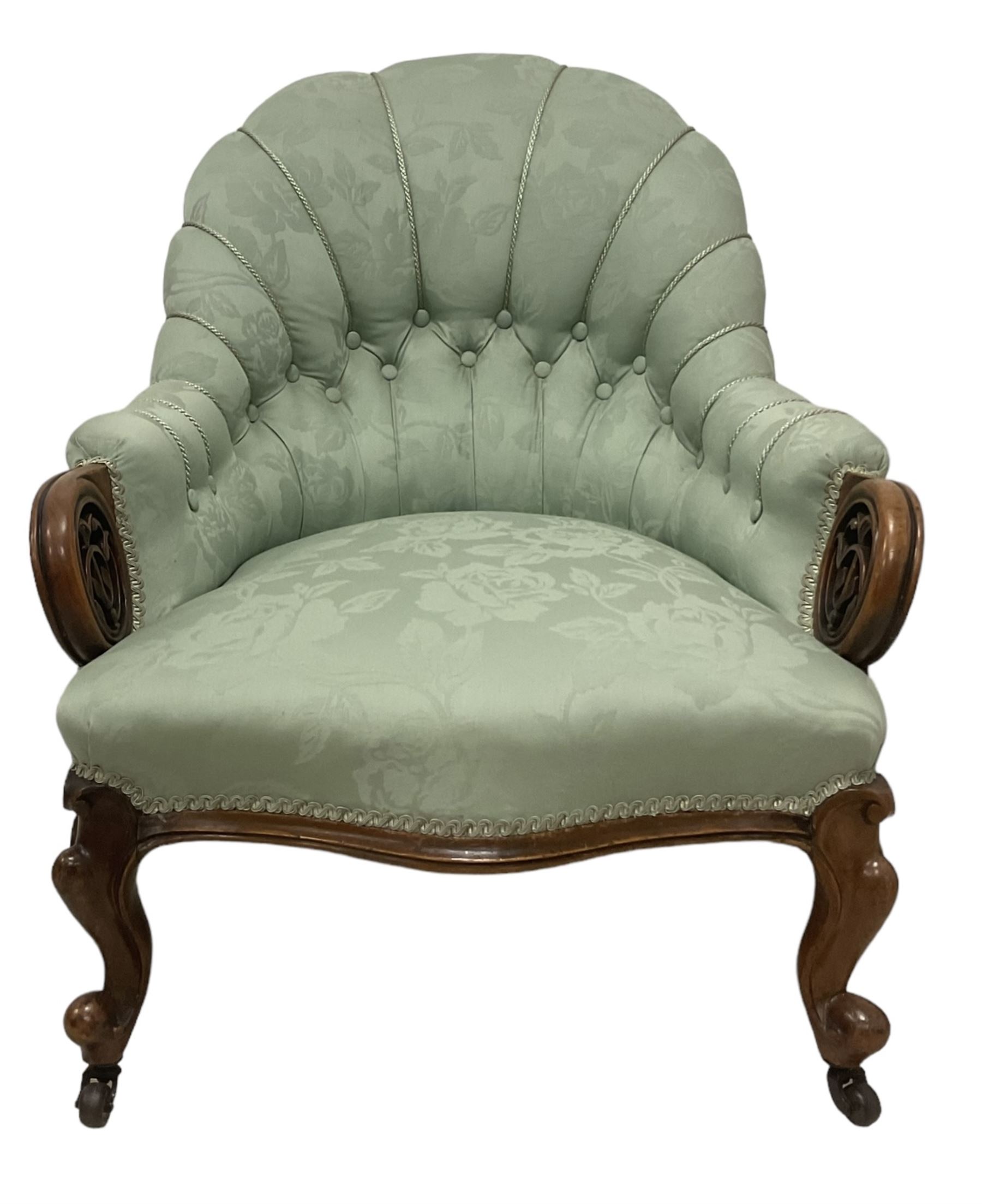 19th century mahogany framed fan-back armchair, upholstered in buttoned turquoise floral damask fabric with spring seat and pearlescent piping, pierced and carved arm terminals with floral motif, over serpentine fronted seat, raised on cartouche carved cabriole supports with castors