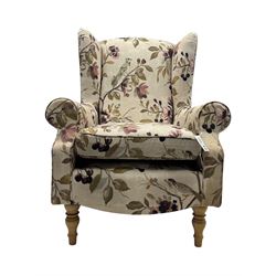 Hardwood-framed wingback armchair, upholstered in cream floral pattern fabric, on turned front feet