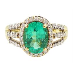 18ct gold single stone oval cut emerald and round brilliant cut diamond cluster ring, with...