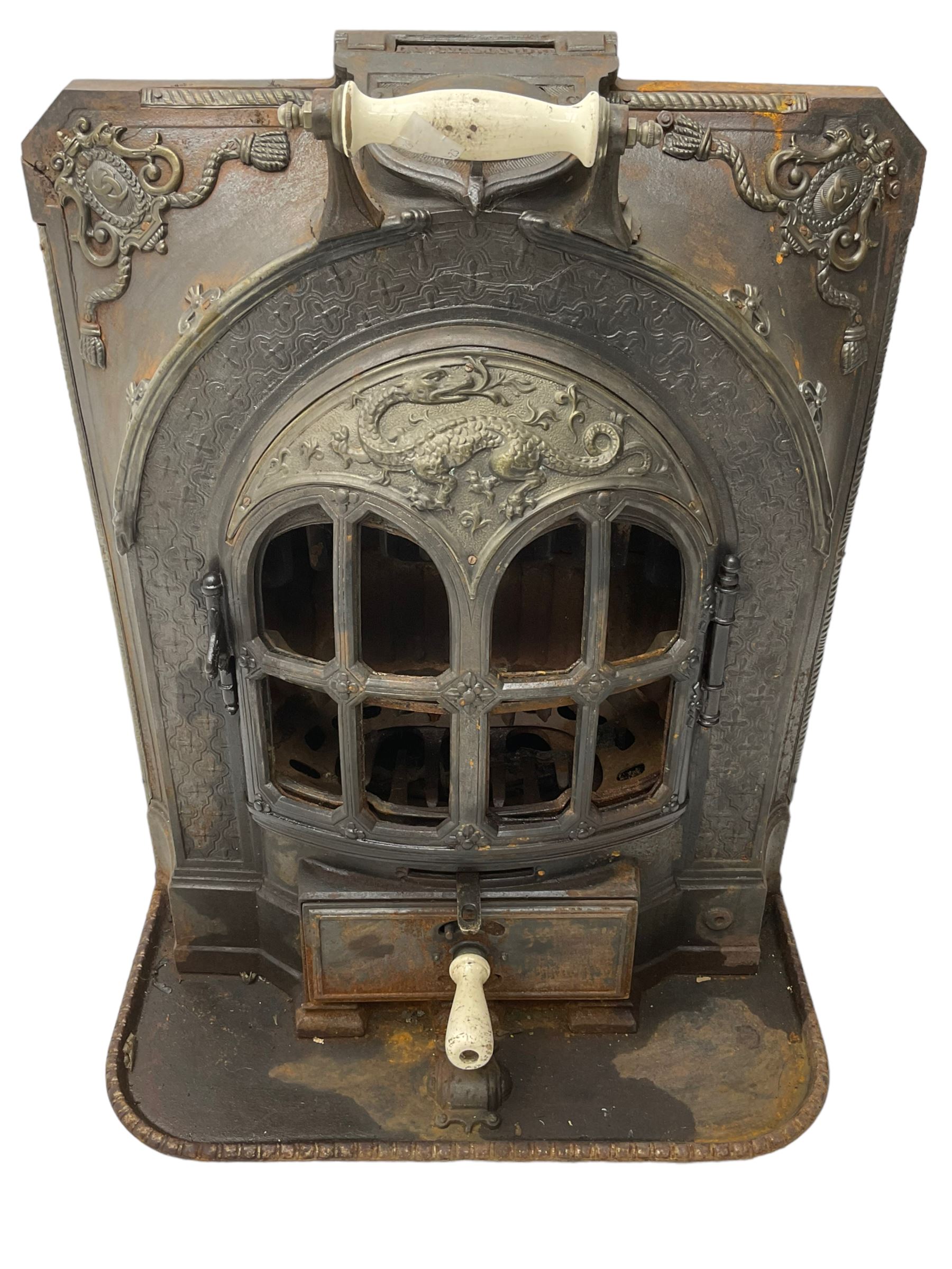 La Salamandre - early 20th century cast iron wood burning stove, decorated with salamander and cartouche motifs, fitted with porcelain handle, on rear castors 