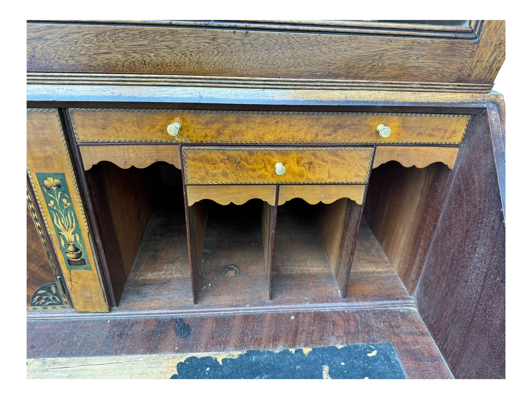 Early 19th century mahogany bureau bookcase, the projecting cornice over two Gothic-style astragal glazed doors enclosing two adjustable shelves, sloped hinged lid enclosing fitted interior and felt inset, four graduating drawers, on bracket feet