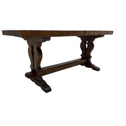 Solid oak coffee table, rectangular waved cut top with tooled ends, on shaped and pierced end supports joined by pegged stretcher 