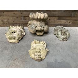 Four grotesque garden wall masks