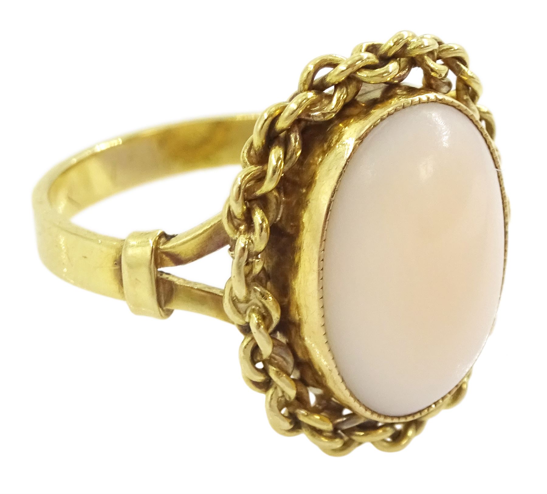 18ct gold single stone coral ring, with chain decoration border, stamped 750