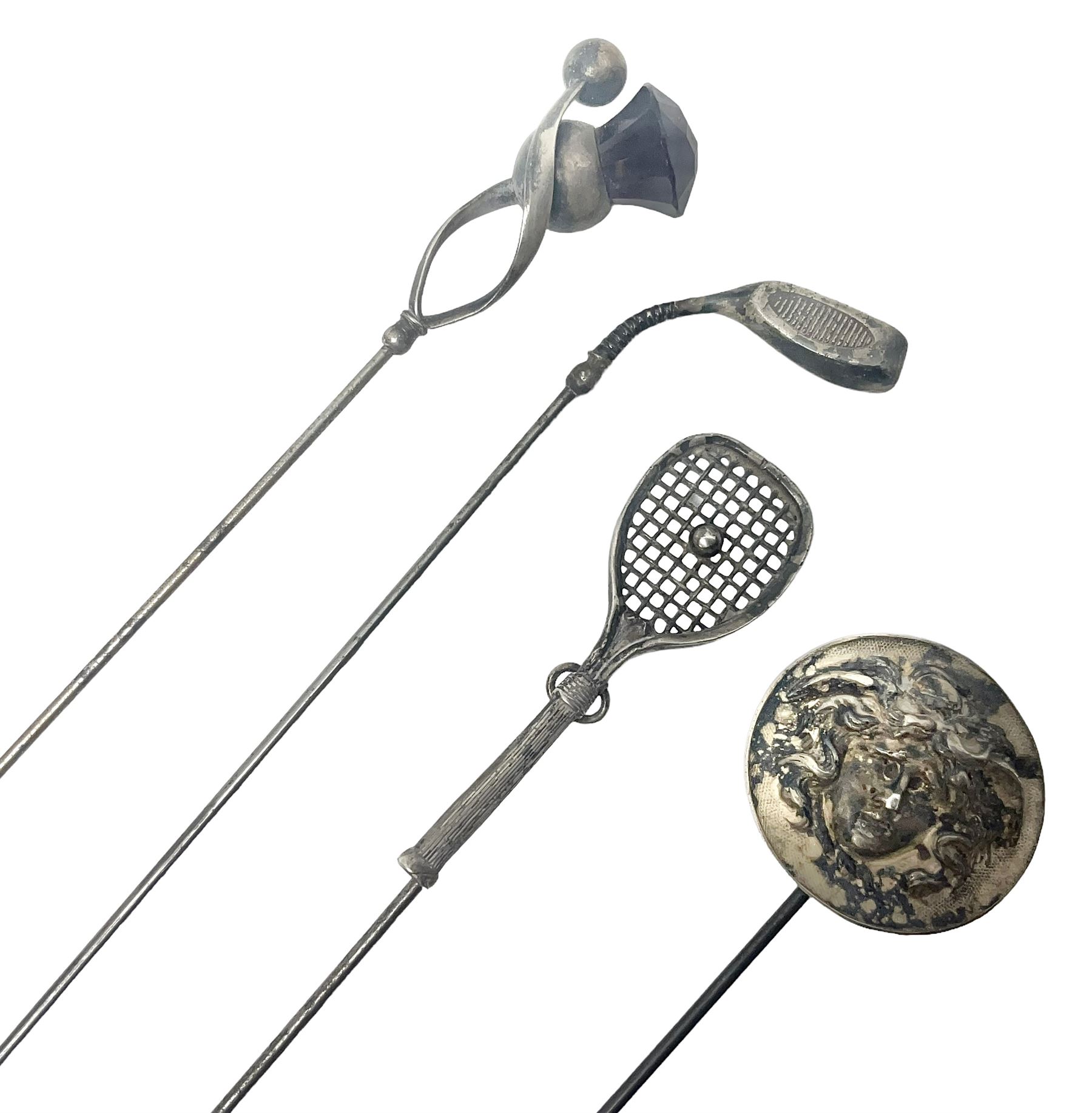 Silver hatpin modelled as a thistle, by Charles Horner, together with three other silver hatpins, modelled as a tennis racket, golf club and Medusa mask, all hallmarked 