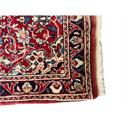 Persian crimson ground rug or mat, field decorated with central medallion and all-over scrolling floral motifs, border with repeating palmettes