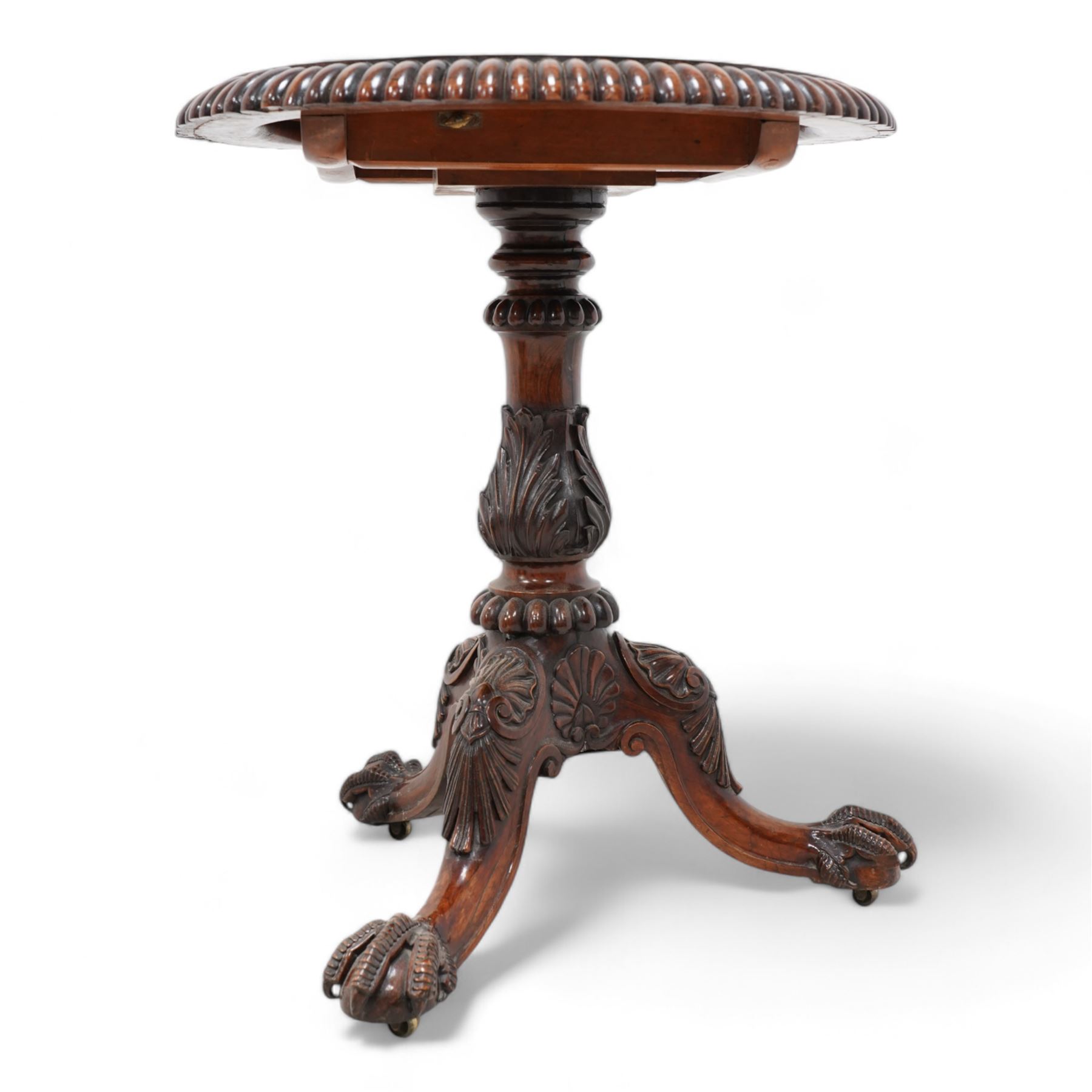 19th century rosewood tripod table, circular tilt-top with gadroon carved edge, turned column with lobed bands and curled acanthus leaf carved baluster, three out-splayed supports with shell carved knees and scaled ball and claw feet, 

Provenance:
Nidd Hall: acquired by Guy Reed from
Richard Butler, 17th Viscount
Mountgarret, in 1968