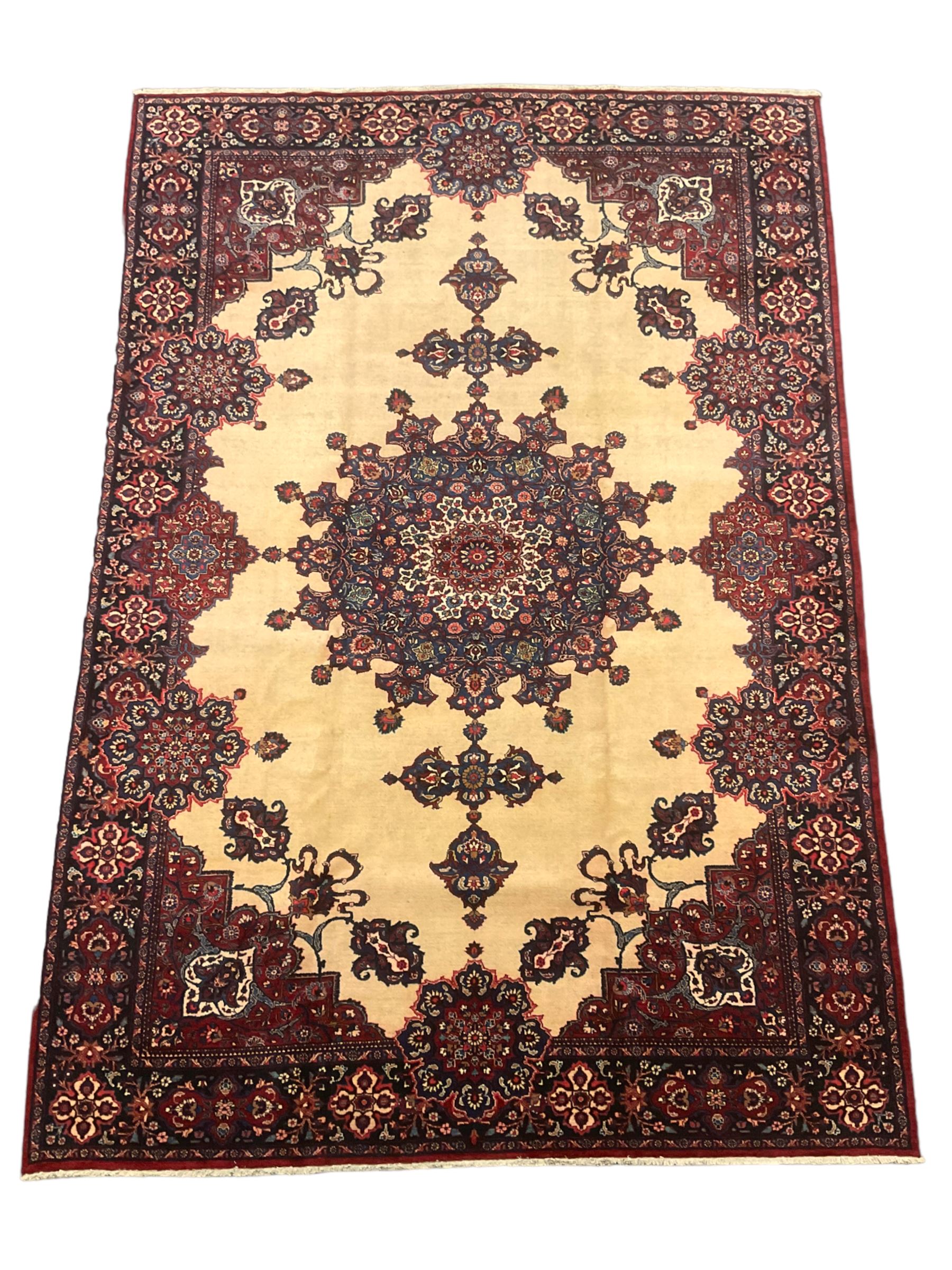 North East Persian Meshed carpet, the field with large central medallion decorated with stylised plant motifs, the field surrounded by panels, medallions and spandrels decorated with floral motifs, indigo ground border with overall floral design 