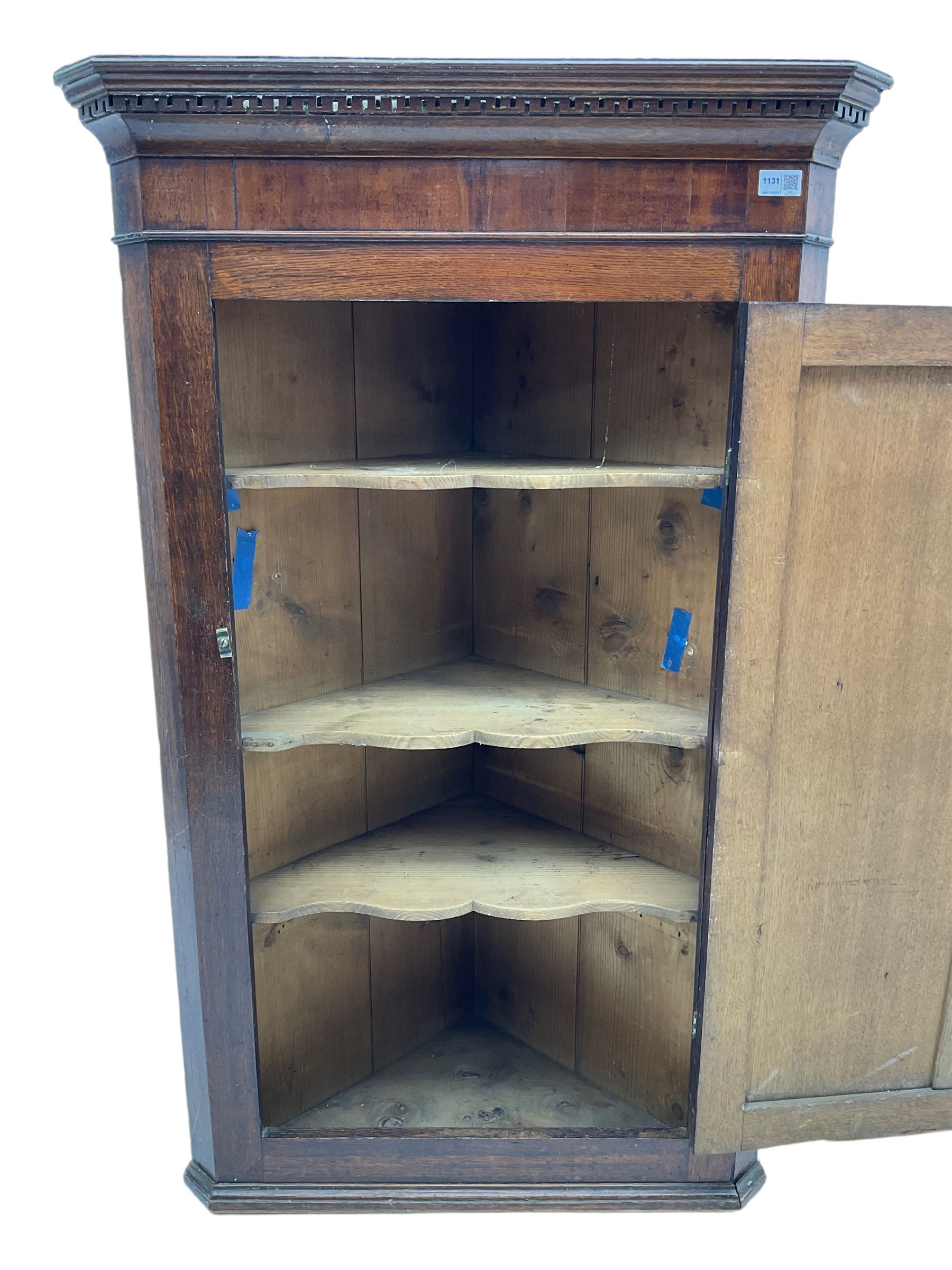 George III oak and mahogany wall hanging corner cupboard, single door decorated with central inlaid shell motif enclosing three shelves