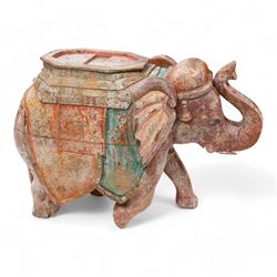 Early 20th century Indian hardwood and polychrome Elephant jardiniere stand, decorated with a headdress and vibrant saddle cloths, surmounted by an octagonal shaped saddle, with overall craquelure finish