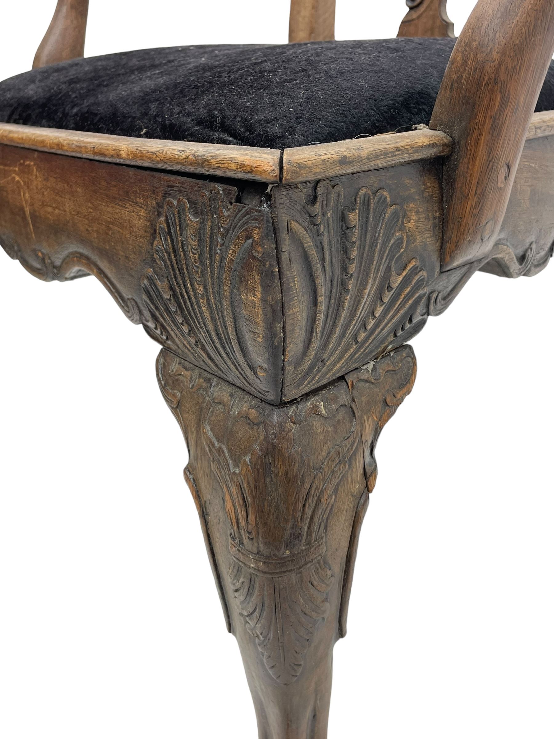 Unusual 18th century mahogany elbow chair, the shaped cresting rail with projecting shell carved ears, pierced and scroll carved splat over drop-in upholstered seat, shaped arms with ball and claw carved terminals, the seat rails carved with shell cartouches, on foliate carved cabriole supports with ball and claw feet 