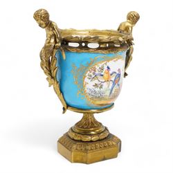 19th century French Sevres style porcelain and gilt brass urn, the body painted with panels of exotic birds and floral sprays within gilt borders on a bleu celeste ground, the handles formed as two cherubs seated upon grasses, upon a laurel leaf cast pedestal base, H20.5cm 