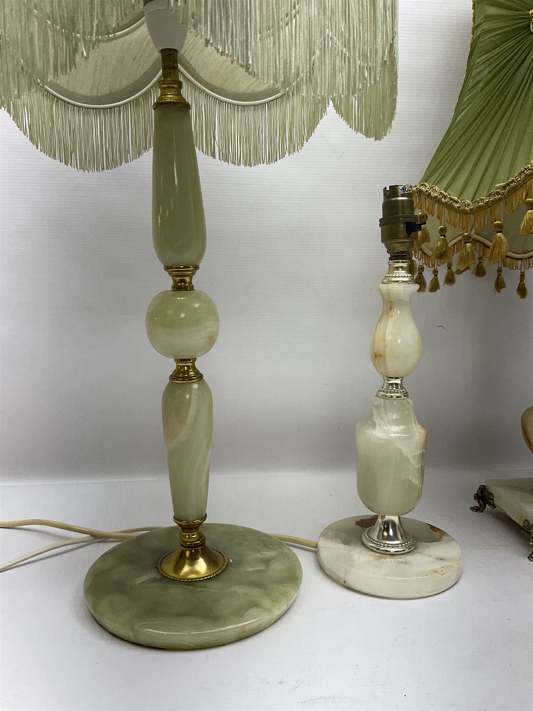 Onyx table lamp, with knopped stem and cream and green tassel shade, together with three smaller similar onyx lamps, classical style alabaster figures and a covered onyx jar