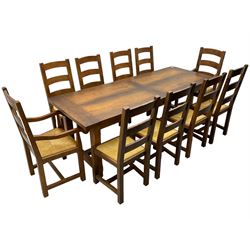 Antix Furniture - oak extending refectory dining table, rectangular plank top with two additional leaves and two drawers to the longer side, on square supports connected by H-stretcher; set of ten (8+2) ladder back dining chairs with rush seats