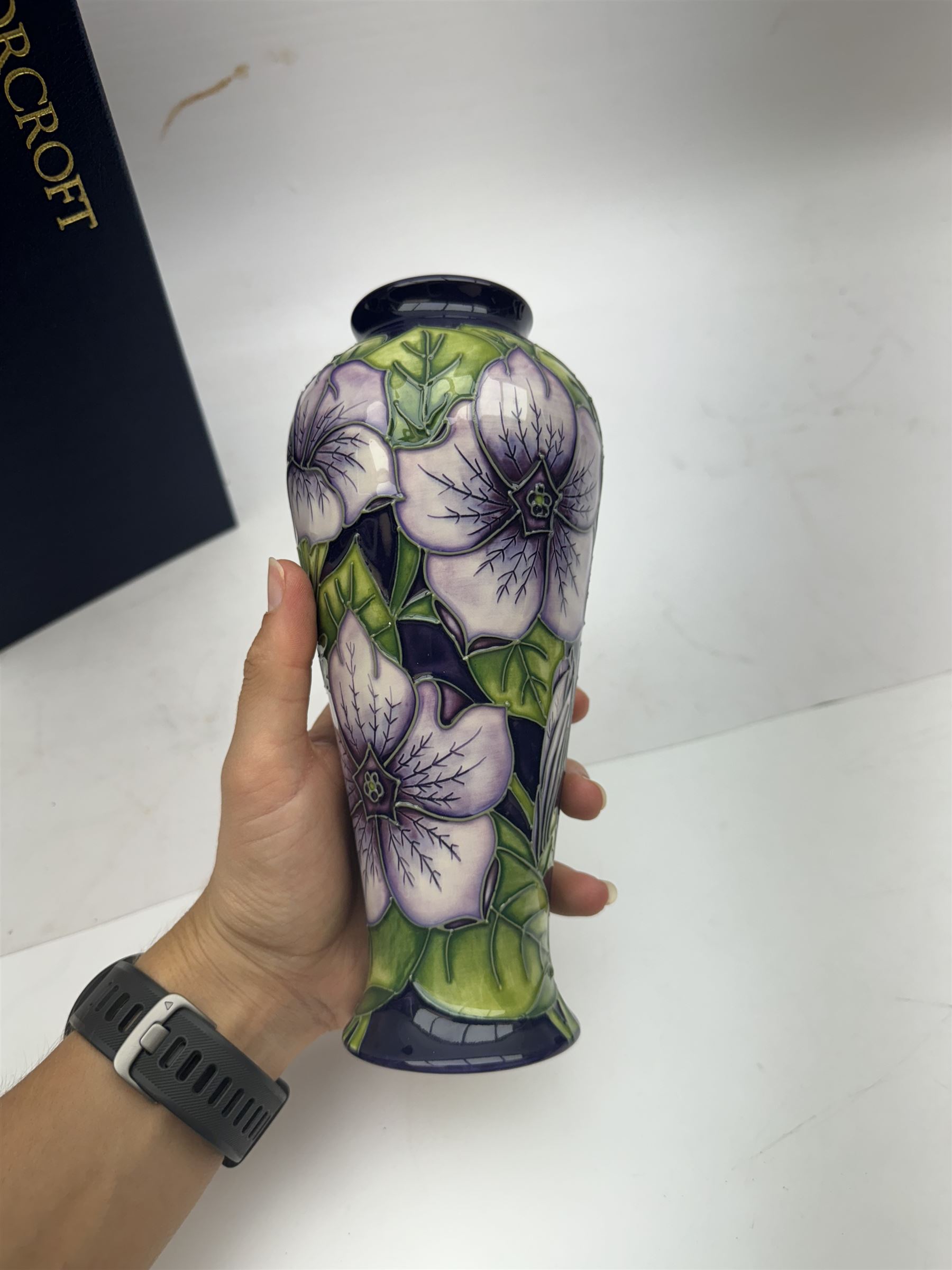 Moorcroft vase in Petunia pattern upon a purple ground, of tall baluster form, marked made for collectables to the base,  with original box, H21cm