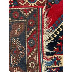 Turkish crimson ground rug, the field decorated with three geometric medallions within a band of star motifs, the main border decorated with stylised plant motifs 