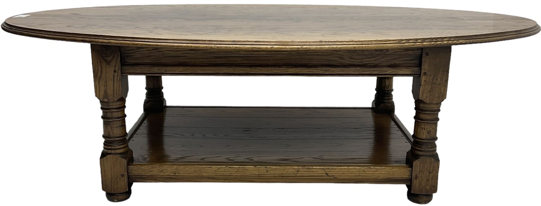 Traditional oak coffee table, moulded oval top, four turned pillar supports united by undertier