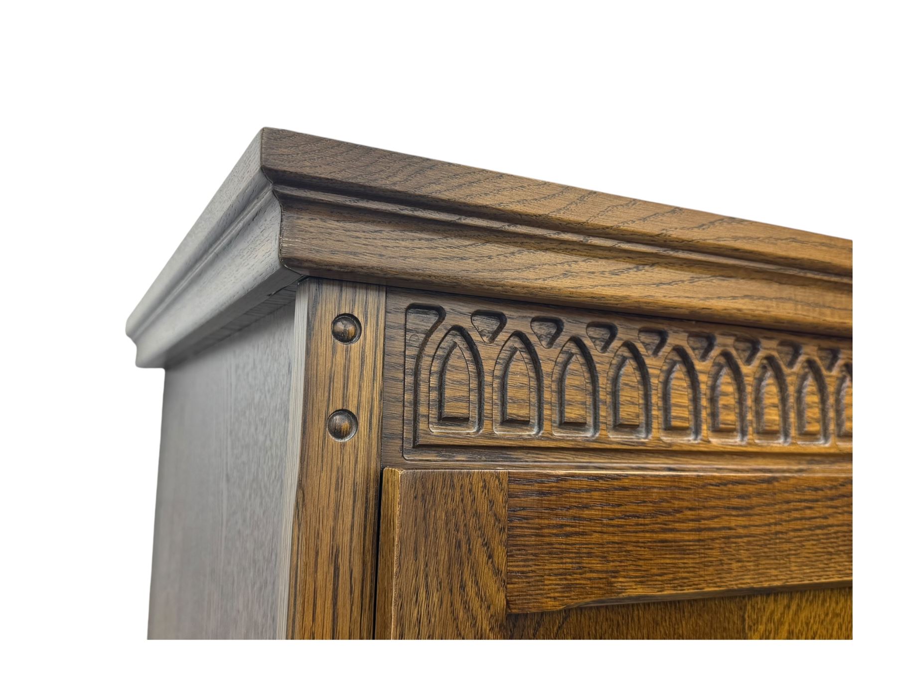 Jacobean design oak double wardrobe, projecting cornice over Gothic arched tracery carved frieze, twin panelled doors with linenfold relief carved detailing, on plinth base