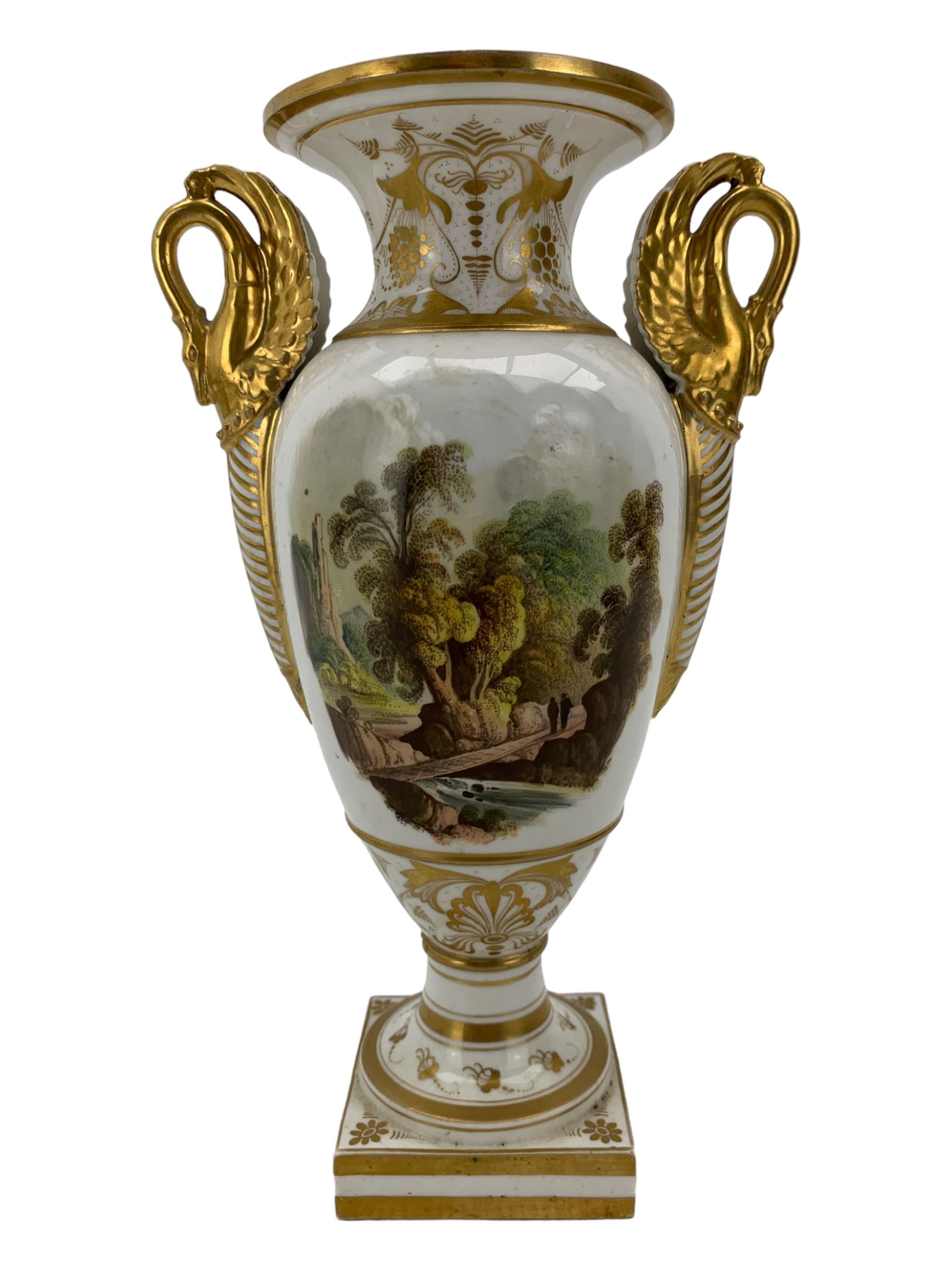 Early 19th century Derby vase, of campana urn form, decorated to one side with a hand painted reserve of a basket of flowers, within a scroll gilt border and twin serpent form handles, H20.5cm together with a Bloor Derby vase, hand painted with figures in a wooded landscape, with twin gilt swan form handles, upon a square pedestal foot, H25cm (2)