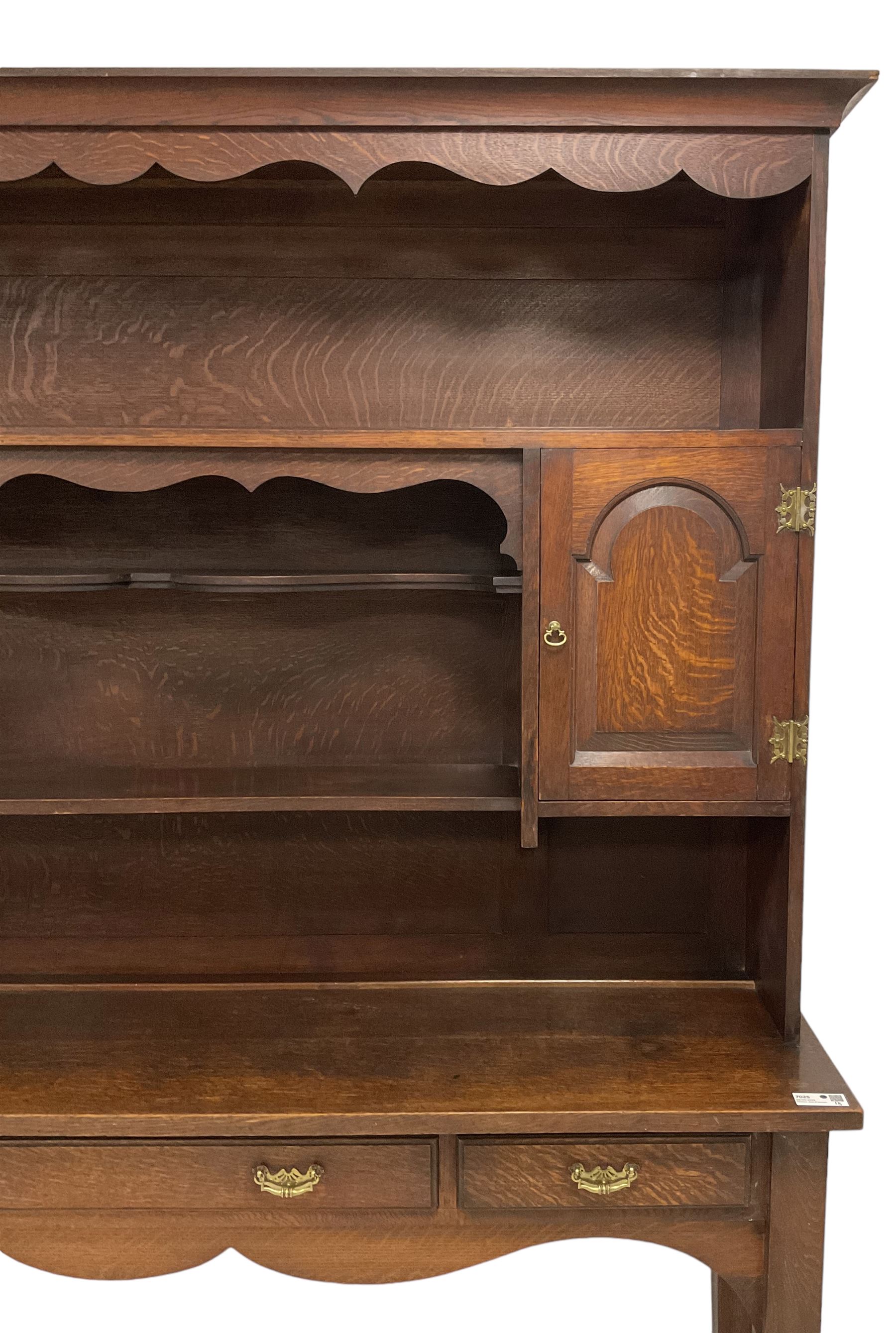 Early 20th century Georgian design oak dresser, projecting cornice with shaped apron over a three-tier plate rack with flanking fielded spice cupboards, the base fitted with three drawers, on turned supports