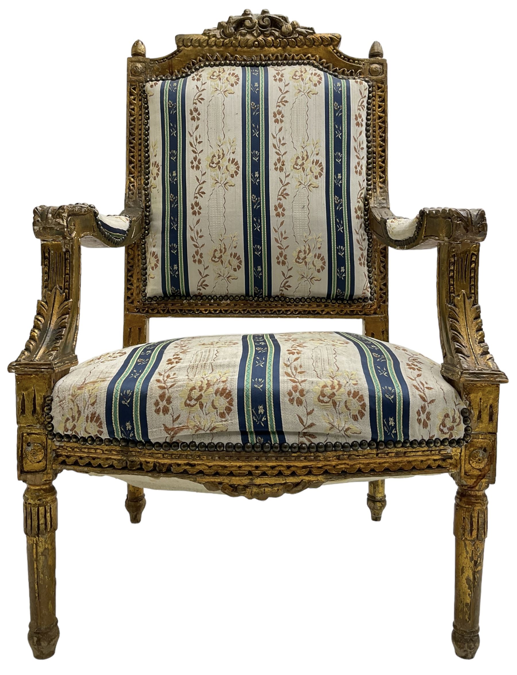 Late 20th century French design carved giltwood armchair, the cresting rail carved with scrolled foliage over foliate carved platform, upholstered in striped fabric decorated with trailing foliage and flower heads, acanthus carved arm terminals and upright supports, on turned and fluted supports 