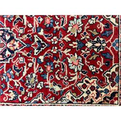 Persian crimson ground rug or mat, field decorated with central medallion and all-over scrolling floral motifs, border with repeating palmettes