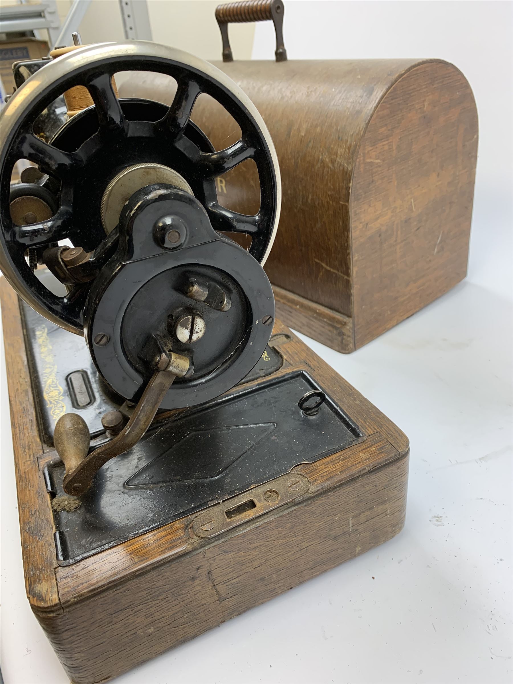 A cased vintage Singer hand crank sewing machine. 