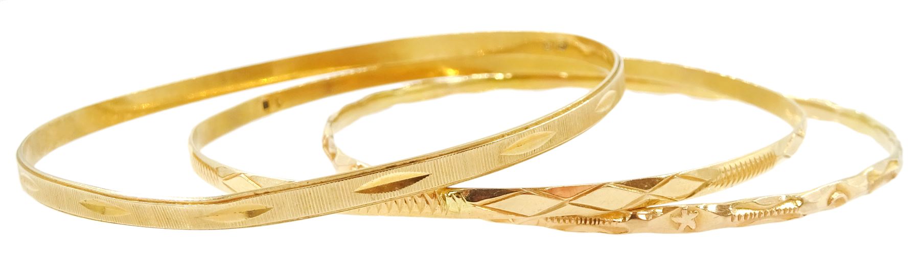 Three Middle Eastern gold bangles, with engraved decoration