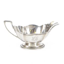 American silver sauce boat, with shaped rim and engraved to body with monogram, upon oval ...