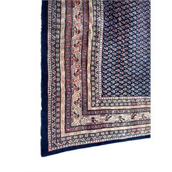 Large North-West Persian Arrak indigo ground carpet, the field decorated all-over with small Boteh motifs, multiple band border decorated with repeating geometric designs