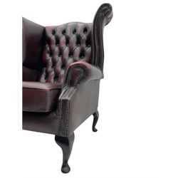 Georgian style wing back armchair, upholstered in oxblood buttoned leather