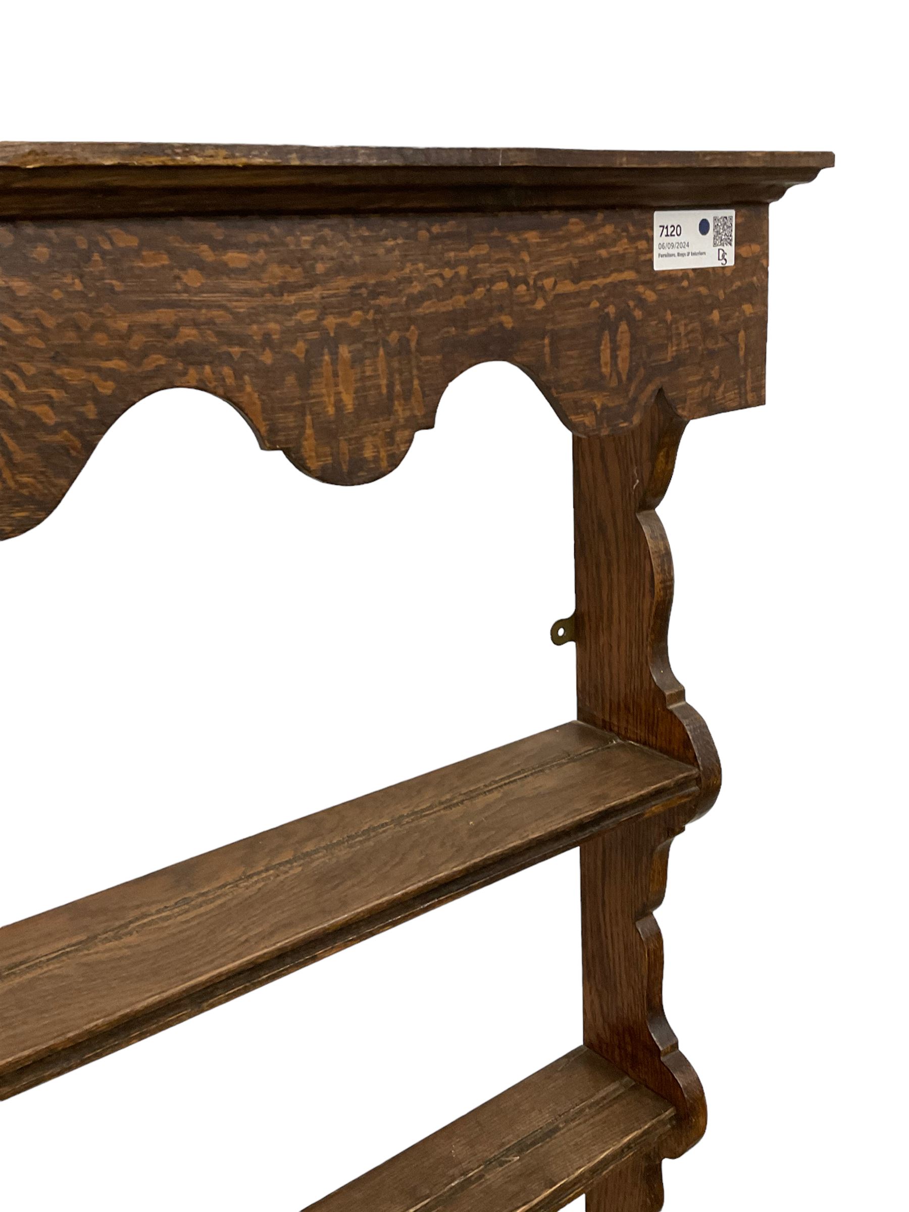 Early 20th century oak wall hanging Delph rack, applied moulded cornice over shaped frieze, three-tiers supports by shaped end supports