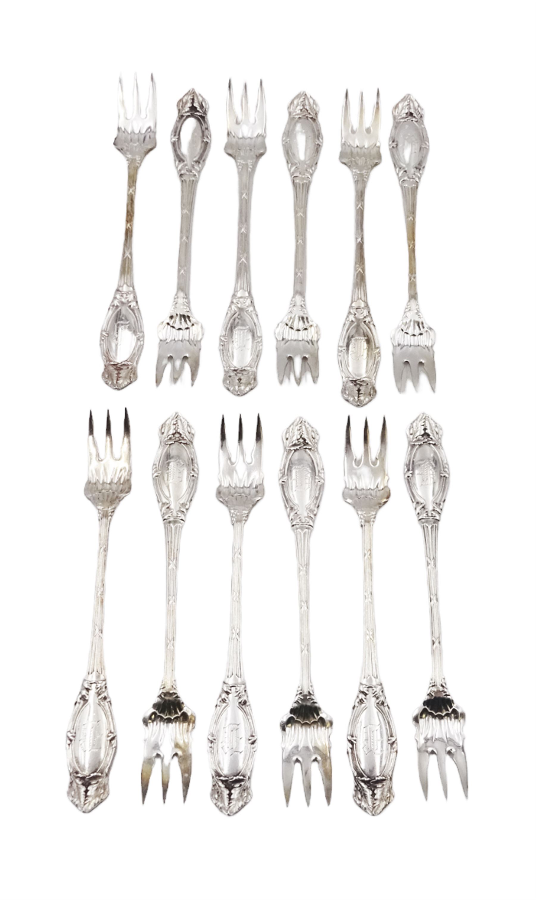 Set of twelve American silver oyster/pickle forks, three pronged forks, the stem decorated with ribbon banding and foliate border surrounding an engraved initial, stamped Sterling 