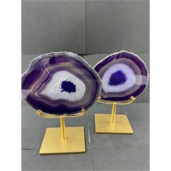 Pair of purple agate slices, polished with rough edges, raised upon gilt metal stands, H22cm