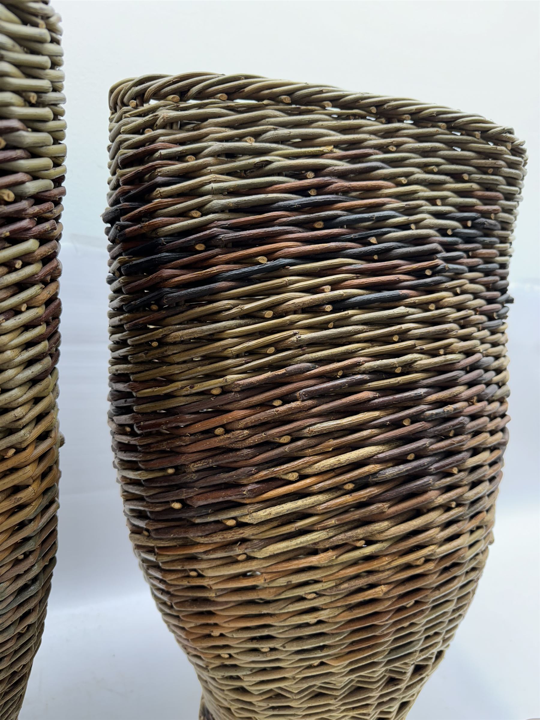 Two rattan baskets, of circular abstract form, together with two crook walking stick, basket H62cm 