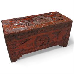 Chinese heavily carved and lacquered camphor wood blanket chest, rectangular hinged top, carved all-over with traditional figural and pagoda scenes with exotic birds, enclosed by a border of stylised clouds