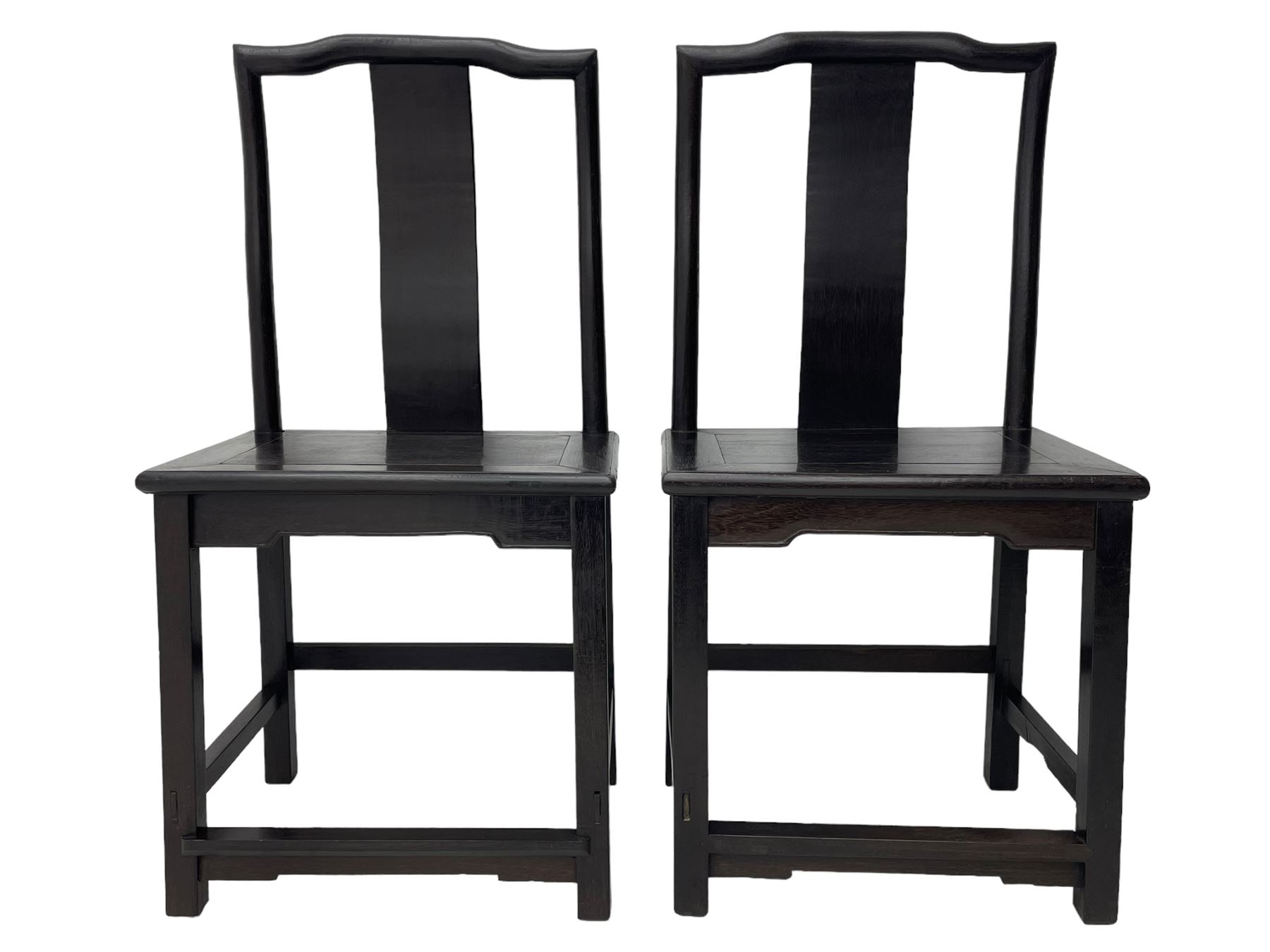 Pair of early 19th century Chinese Qing dynasty black wood side chairs, yoke cresting rail over shaped back panel, panelled rectangular seat on square supports united by stretchers 