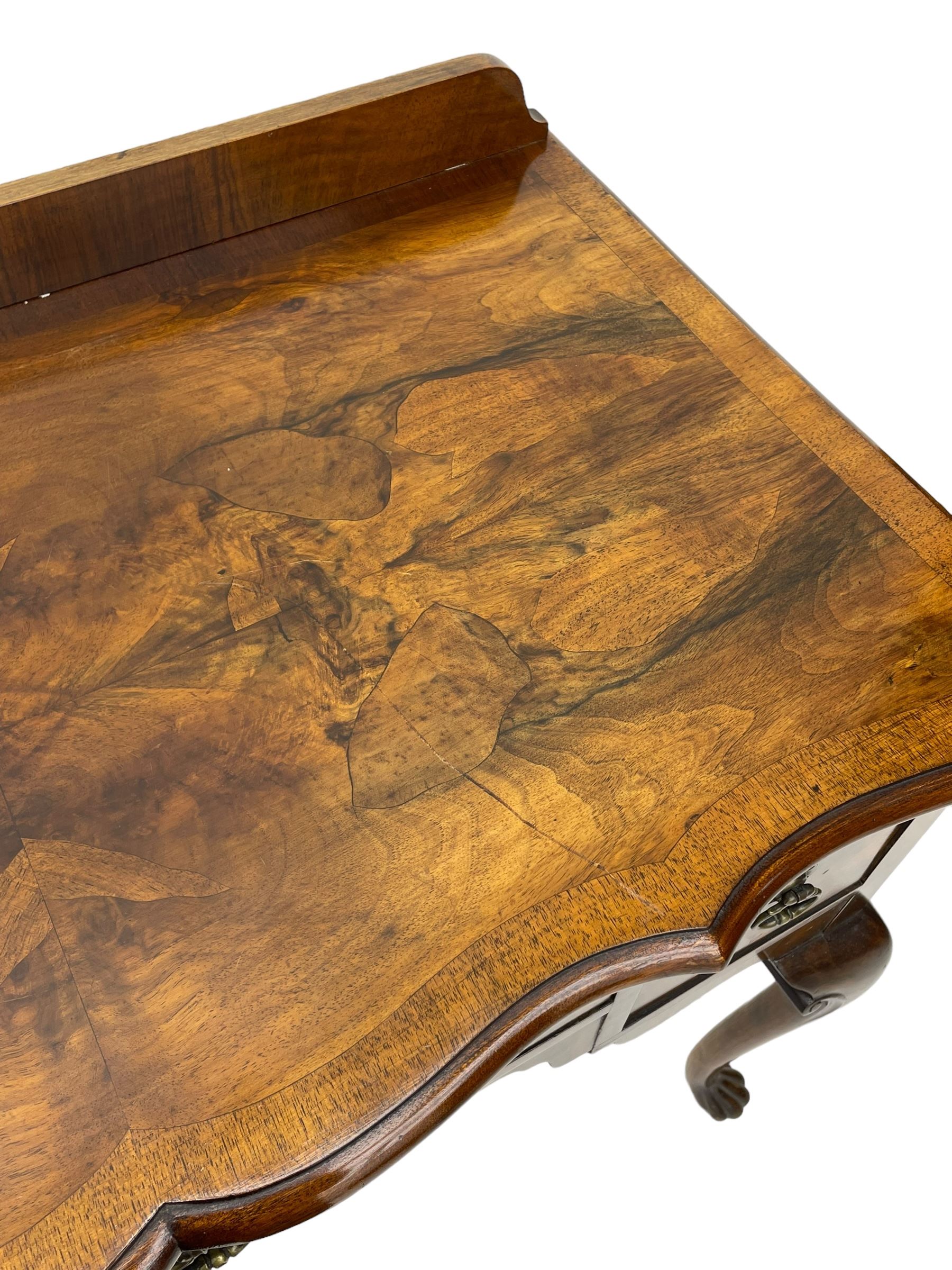 Mid-to-late 20th century figured walnut side table, raised back over figured top with cross banding and shaped front, fitted with three drawers, on cabriole supports with carved terminals 