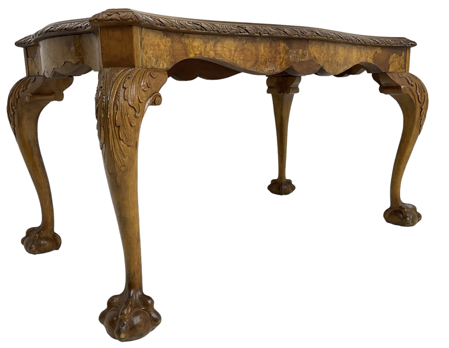 Mid-20th century figured walnut serpentine coffee table, inset glass top and foliate carved edge, raised on cabriole supports with acanthus moulded knees and ball and claw feet