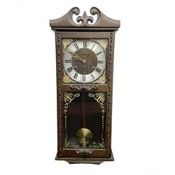 Month going twin train spring driven wall clock - in a glazed oak case with a swan necked pediment, silvered chapter ring with Roman numerals and gilt hands, with cast brass spandrels and a visible pendulum, striking movement, sounding the hours and half hours on a gong.