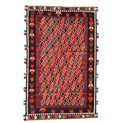 Southwest Persian Qashqai Kilim crimson ground rug, decorated with a repeating geometric pattern of interlocking diamond motifs in red, green, blue, and brown, enclosed by a deep brown border with stylised floral motifs and colourful fringe accents