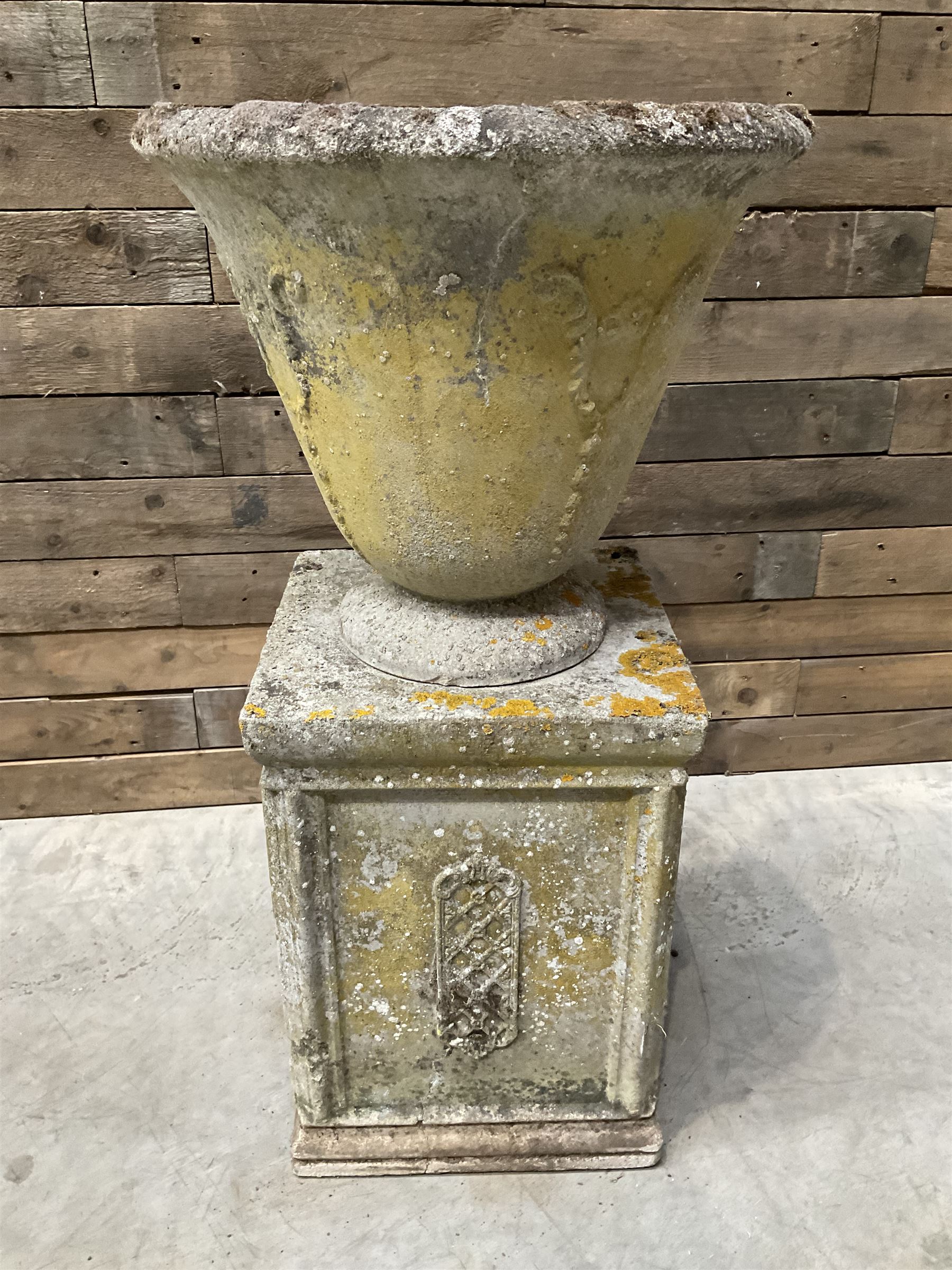 Cast stone vase shaped urn, mounted on square plinth